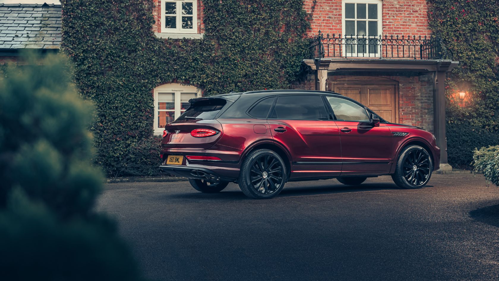 Red Bentayga EWB Mulliner parked in the driveway of a large family home