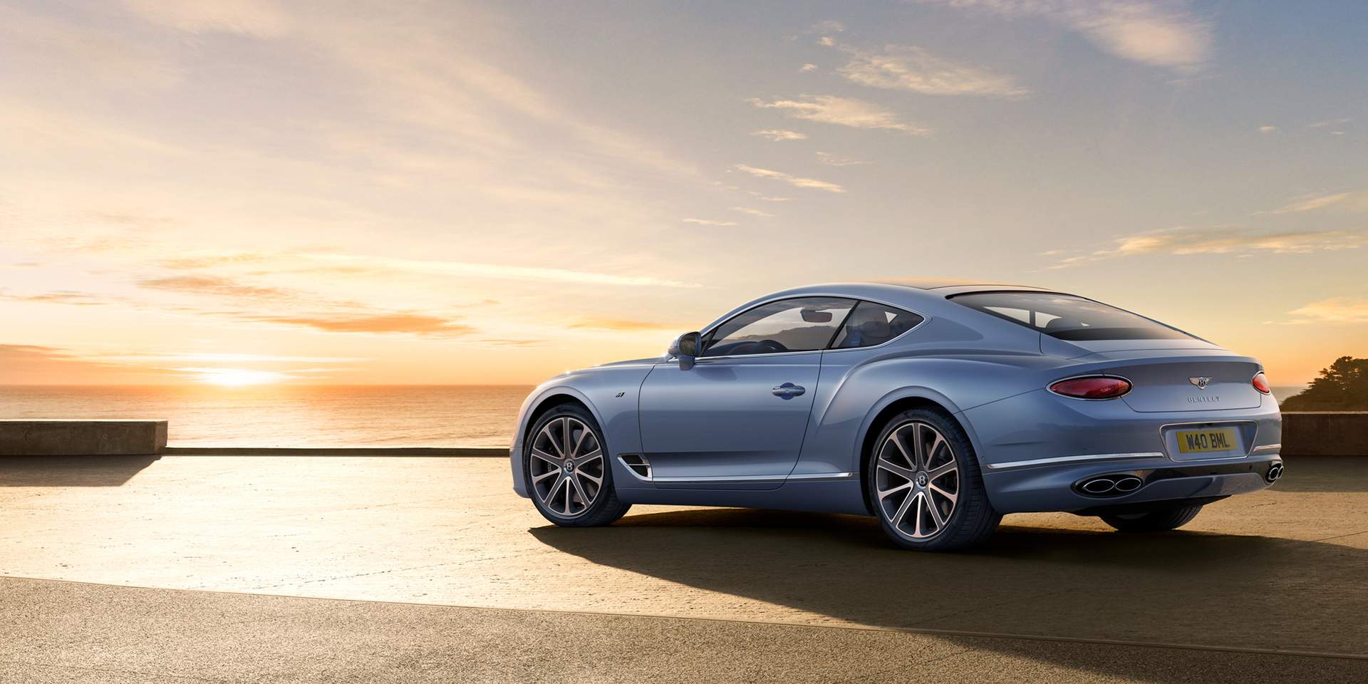 Blue Continental GT A parked and looking over a sunset