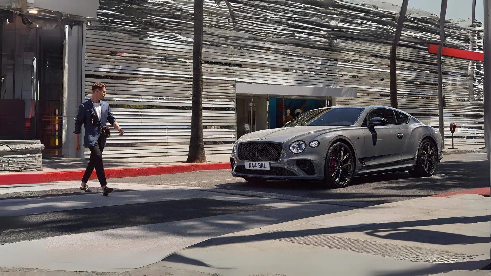 Bentley Continental GT S parked in the street while a stylish male crossing the road is looking at it.