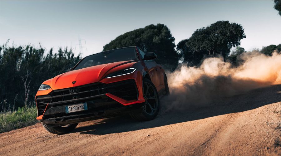 An Urus SE driving on a dirt road