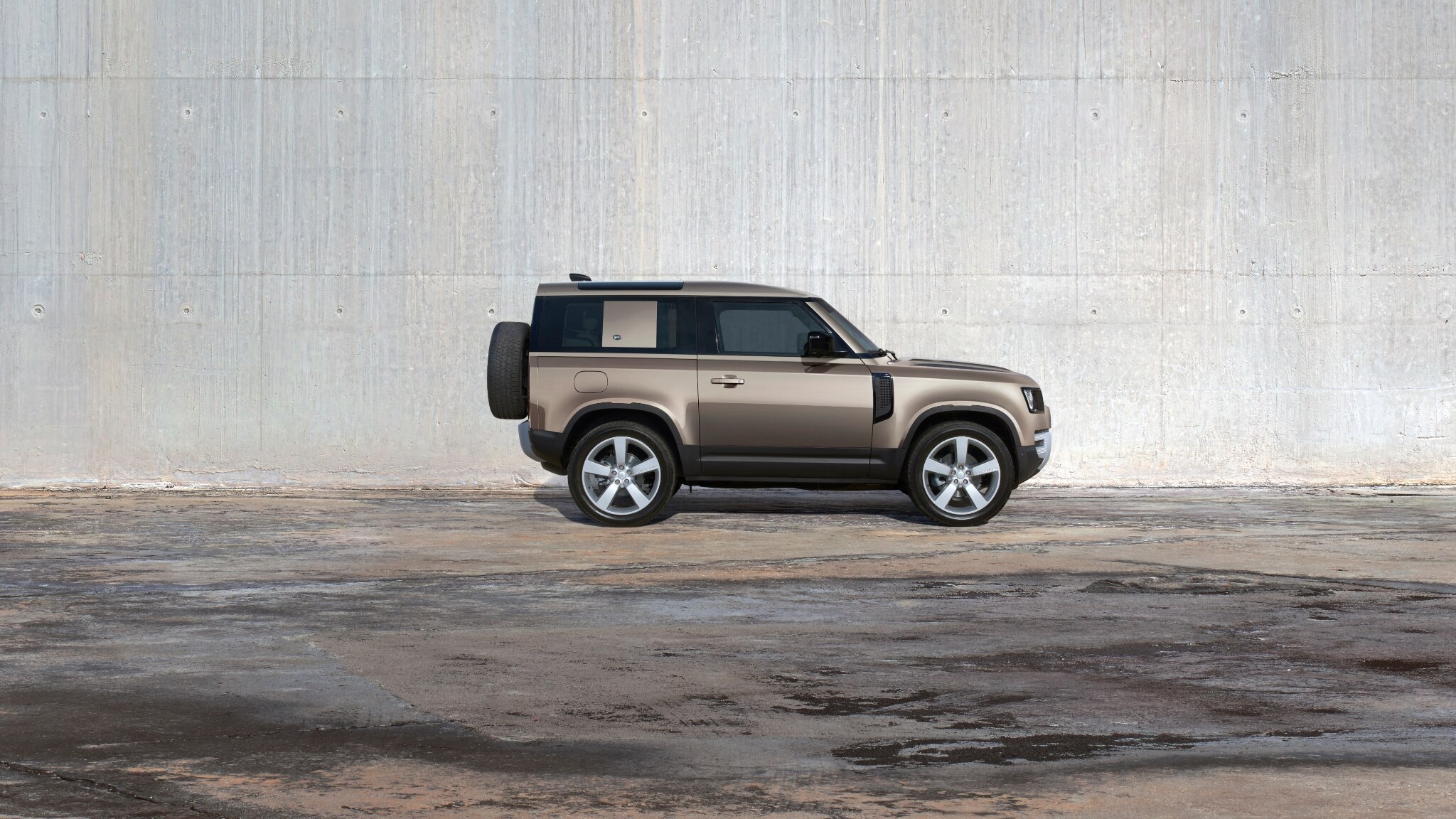 Defender 90 side on against a grey wall
