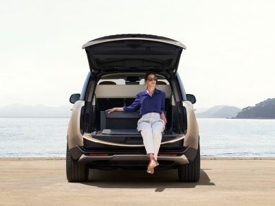 Range Rover with a woman sitting in the open boot